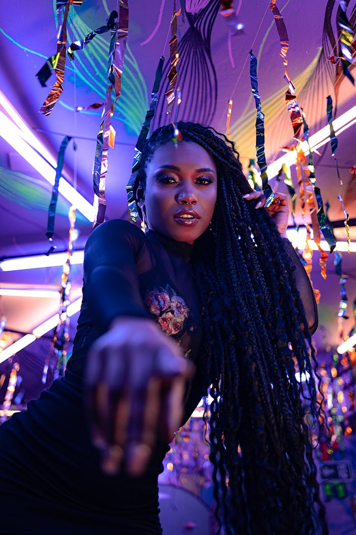 African American woman dancing in a vibrant nightclub with neon lights.